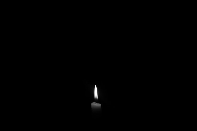 Zapálená sviečka v tme